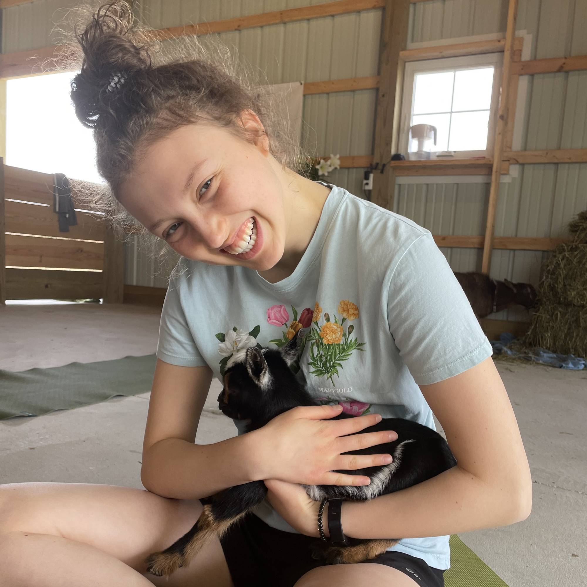 Smiling girl holding a goat